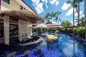 A pool area with a swan float, palm trees, and a bar area with a thatched roof. - Boutique Resort Private Pool Villa (Pa Klok)
