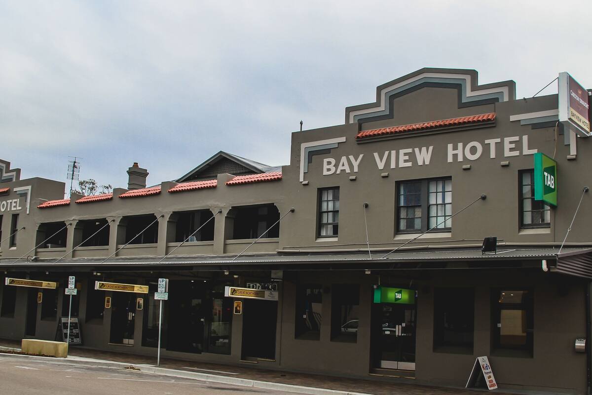 La façade extérieure de l’hôtel Bay View, avec une enseigne indiquant la présence d’un restaurant TAB.