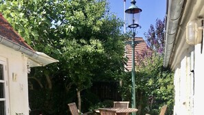 Ein Patio-Bereich mit Gartenmöbeln und Kübelpflanzen.
