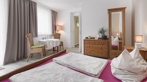 A hotel room with a bed, a chair, a table, a dresser, and a mirror. - Typically Saxon! Cozy little apartment in the heart of Dresden. (Dresden)