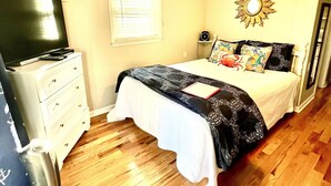 A bedroom with a bed, a dresser, a television, and a ceiling fan. - Prime Location 1 Bedroom 1 Bath! (Carolina Beach)