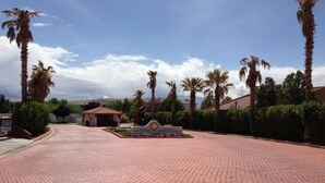 Un chemin pavé mène à un bâtiment sur lequel est apposée une enseigne indiquant « Las Palmas Resort & Spa ».