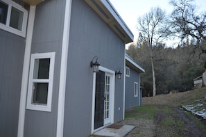 A two-story house with a gray exterior, white trim, and a front door with a glass panel.