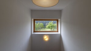 A room with a skylight, a small window, and a wall-mounted light fixture.