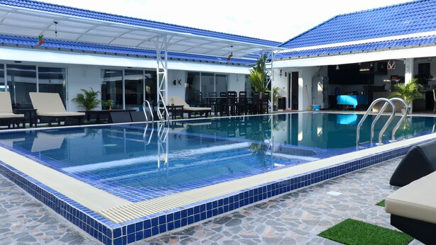 A swimming pool with lounge chairs and a covered patio area. - Good Time Boutique Hotel (Sihanoukville)
