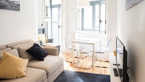 Una sala de estar con un sofá, una mesa y sillas.
