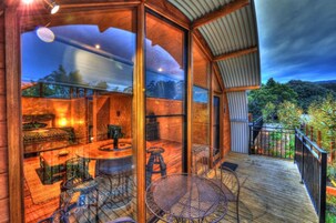 Un espacio interior amplio con una terraza de madera, una mesa de comedor y sillas.