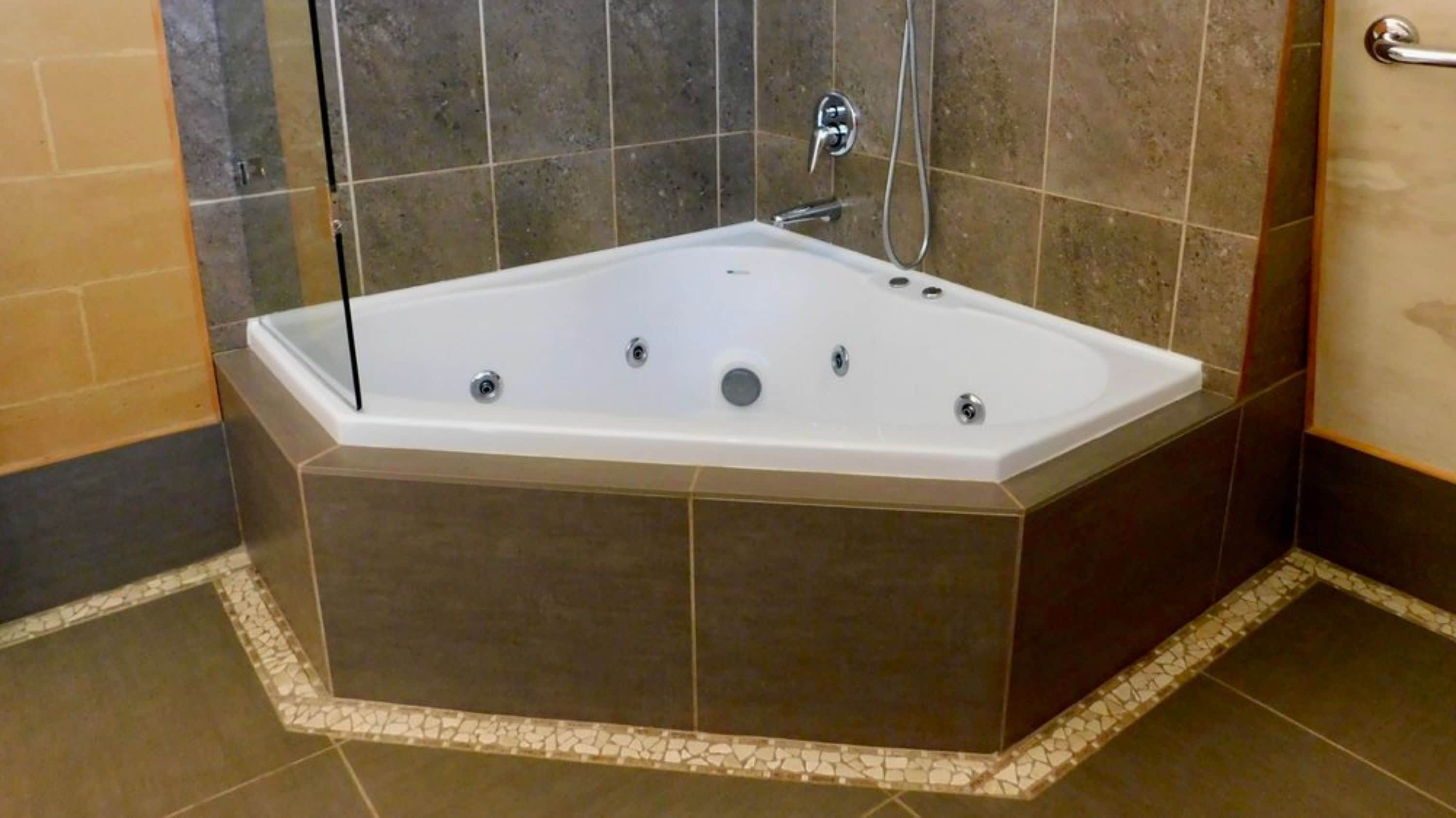 A modern bathroom with a freestanding bathtub, a shower area, and a tiled floor.