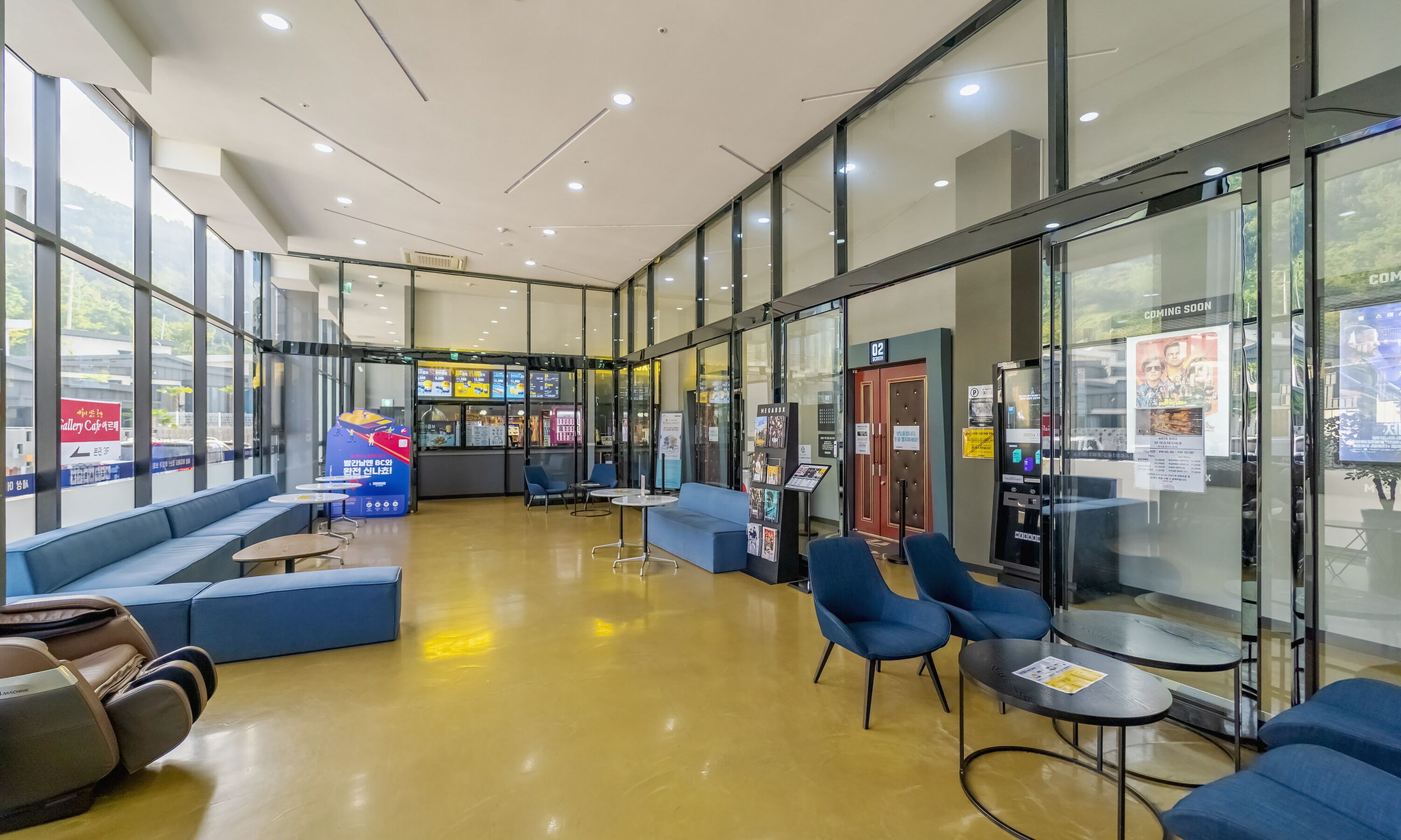 A spacious lobby with seating areas, a vending machine, and a view of the outside.