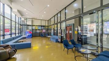 A spacious lobby with seating areas, a vending machine, and a view of the outside.