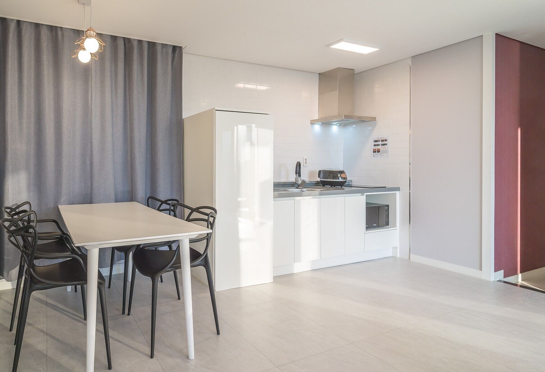 A modern kitchen with white cabinets, a built-in oven, and a microwave.