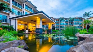 Ein Hotel mit Pool, großen Felsen und üppiger Vegetation.