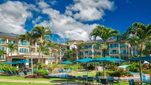Ein Resort mit Pool, Palmen und mehreren Balkonen.