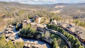 Un gran resort con varias construcciones, un camino sinuoso y montañas al fondo.