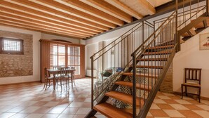 A spacious room with a checkered floor, a wooden staircase, and a stone wall. - XV century villa recently restored , located on Colà di Lazise (Colà di Lazise)