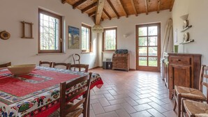 A spacious room with a high wooden ceiling, a large window, a table with a colorful tablecloth, and a radio. - XV century villa recently restored , located on Colà di Lazise (Colà di Lazise)
