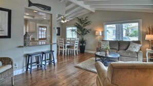A spacious living area with a dining table, chairs, a sofa, and a coffee table. - Enjoy Ocean View from Large Private Patio, A/C & Garage (Corona del Mar)