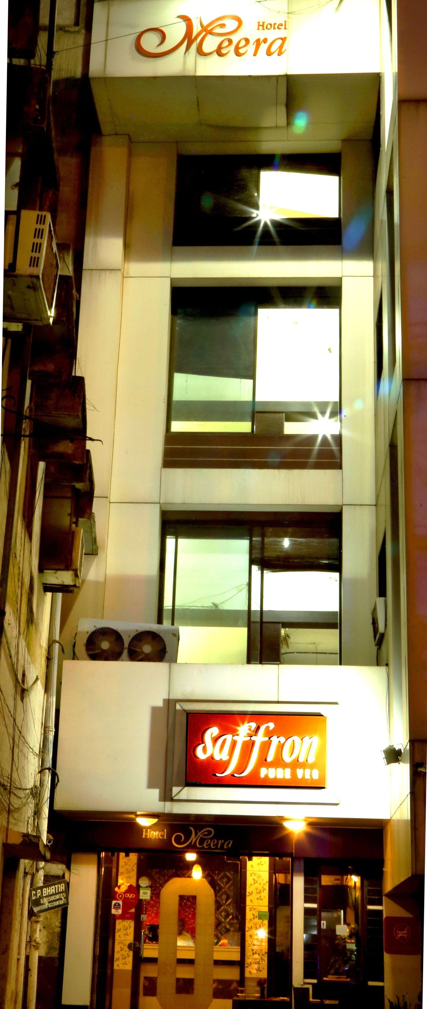 A hotel named "Hotel Meera" with a sign for "Saffron Pure Veg" restaurant.