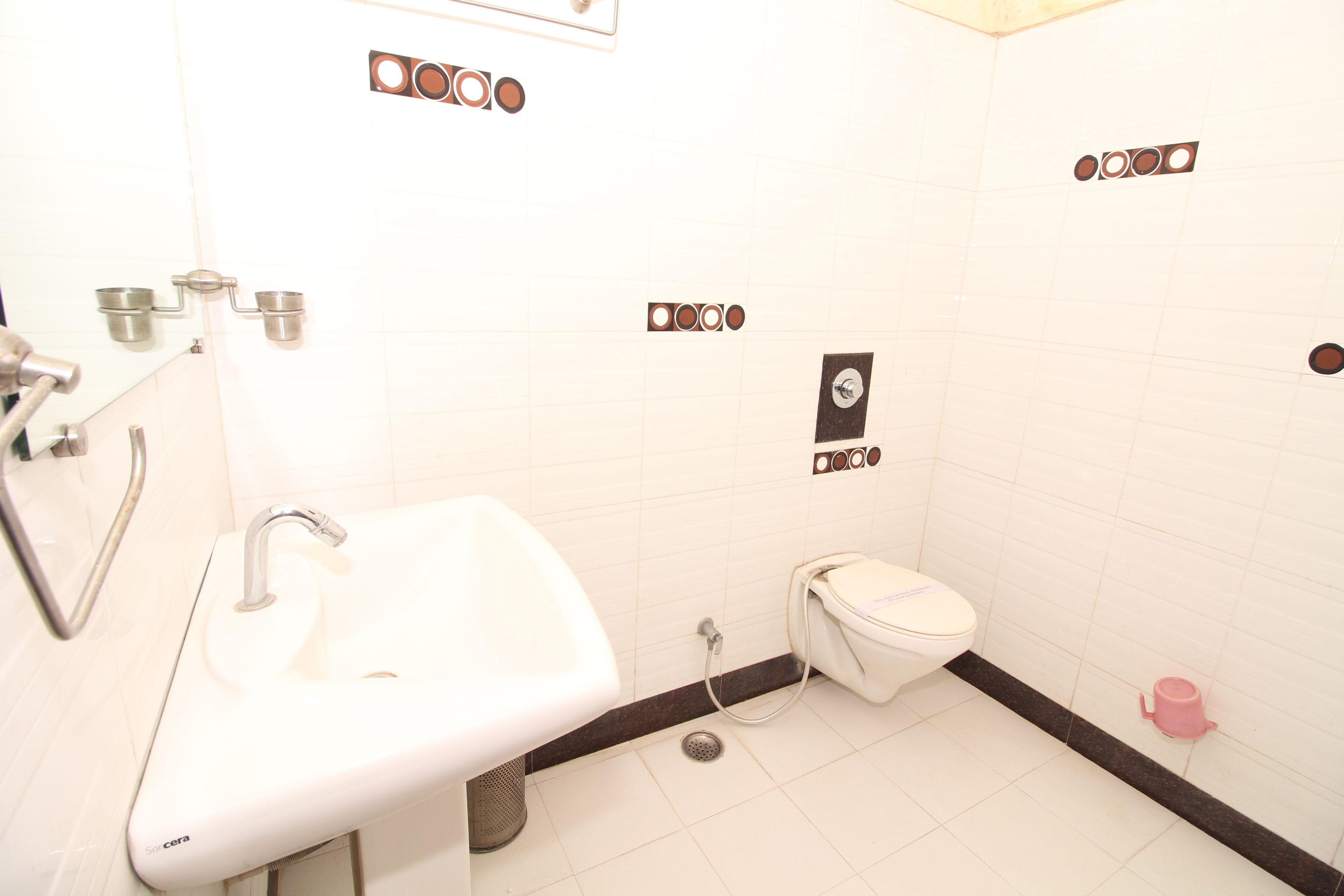 A bathroom with a white sink, toilet, and a shower.