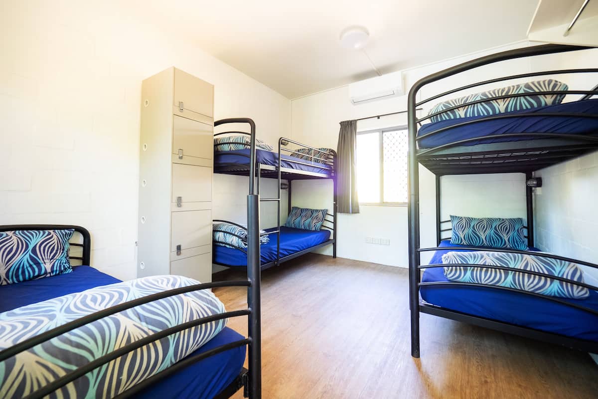 Una camera del dormitorio con letti a castello, un armadio e una finestra con tende.