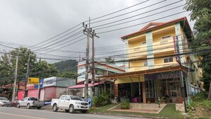 A multi-story building with a ground-level shop and a visible balcony. - Pachumas Mansion (Karon)