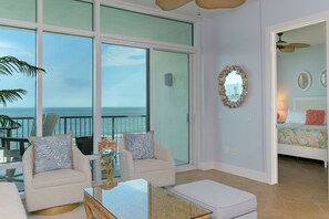 Relax in a spacious living area with a sliding glass door leading to a balcony overlooking the ocean.