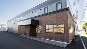 A modern hotel with a brick facade, large windows, and a sign indicating it is Hotel R9 Sanfujikoka. - Hotel R9 Sano Fujioka (Sano)