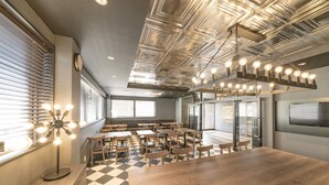 A modern conference room with a large wooden table, multiple chairs, and a ceiling with exposed ductwork and lighting fixtures. - Hotel R9 Sano Fujioka (Sano)