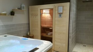 Un sauna en bois avec un banc et une serviette, une porte en bois et un panneau de commande.