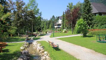 A park with a gravel path, benches, and a small stream.