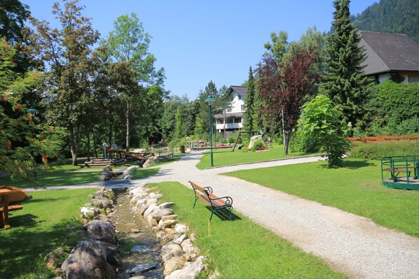 A park with a gravel path, benches, and a small stream. - Sunny apartment within walking distance of the ski slope, free ski depot (Russbach)