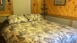 Un dormitorio con una cama, cabecera de madera, un reloj de pared y una cita motivacional.