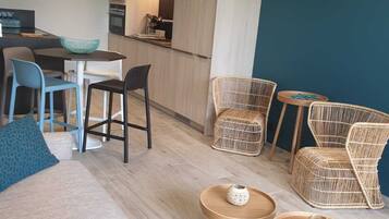 Un salon moderne avec un canapé, des fauteuils et un petit coin repas.