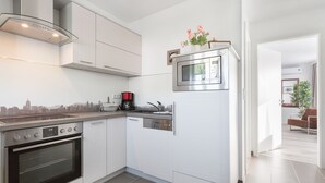 A modern kitchen with white cabinets, a built-in oven, a microwave, and a coffee maker. - Sunny days in our dreamlike, beautiful Dresden! (Center) (Dresden)
