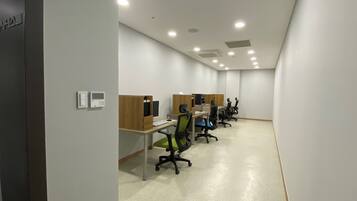 Un espacio de oficina moderno con estaciones de trabajo individuales, cada una equipada con una computadora, teclado y silla.