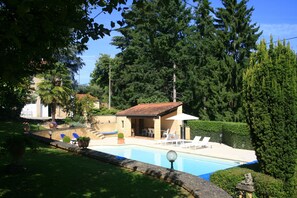 A swimming pool with lounge chairs and a small patio area. - For rent small country house located in the heart of p. black (Sarlat-La-Canéda)