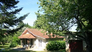 Een huis met een pannendak, een overdekte patio en een rode garage.