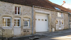 A two-story stone building with a garage door, multiple windows, and a satellite dish on the roof. - Detached 3-star house in a village with shops (Sarrey)