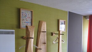 A wooden bench with three wooden sculptures against a green wall. - Detached 3-star house in a village with shops (Sarrey)