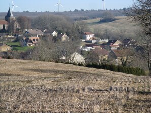 A rural landscape with houses, wind turbines, and a church.