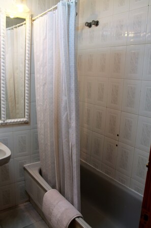 Een bad/douchecombinatie, een haardroger, een bidet, handdoeken