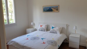 A bedroom with a bed, two bedside tables, a window, and a painting on the wall. - QUIET LANDAISE HOUSE ON THE EDGE OF A 3-STAR FOREST (Labenne)