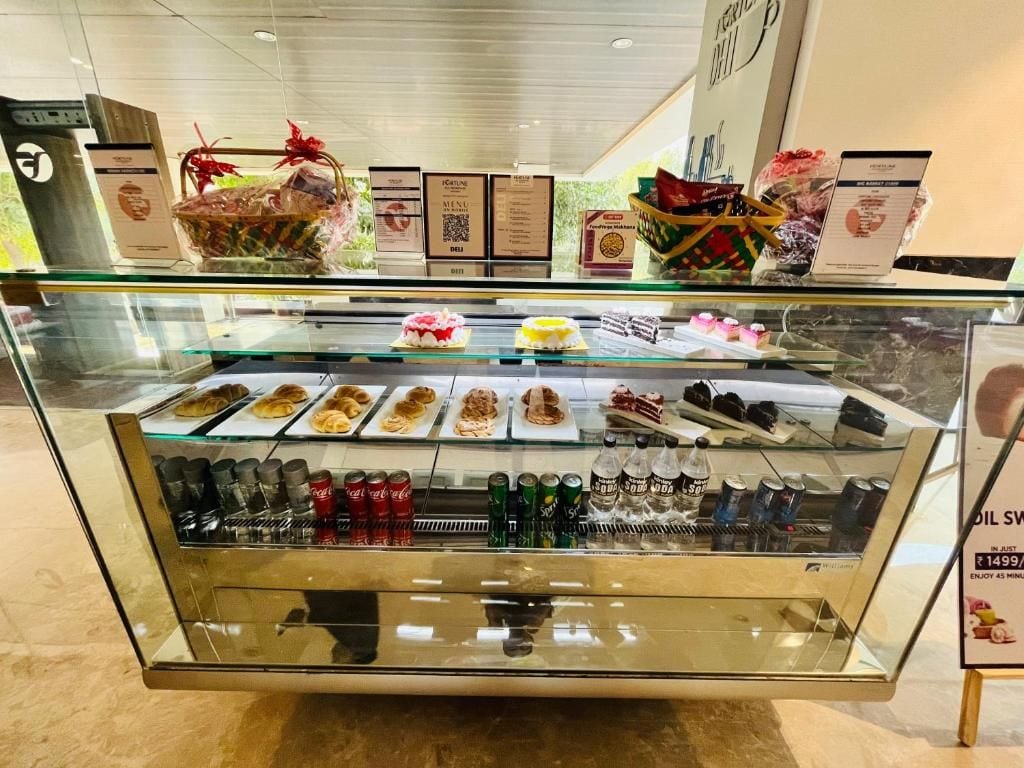 A bakery display case with various baked goods and beverages.