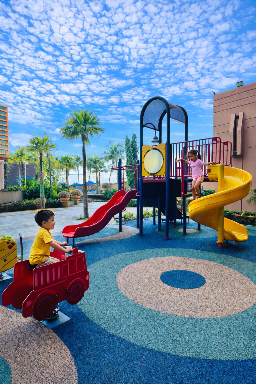 A children's play area with slides and a red toy car.