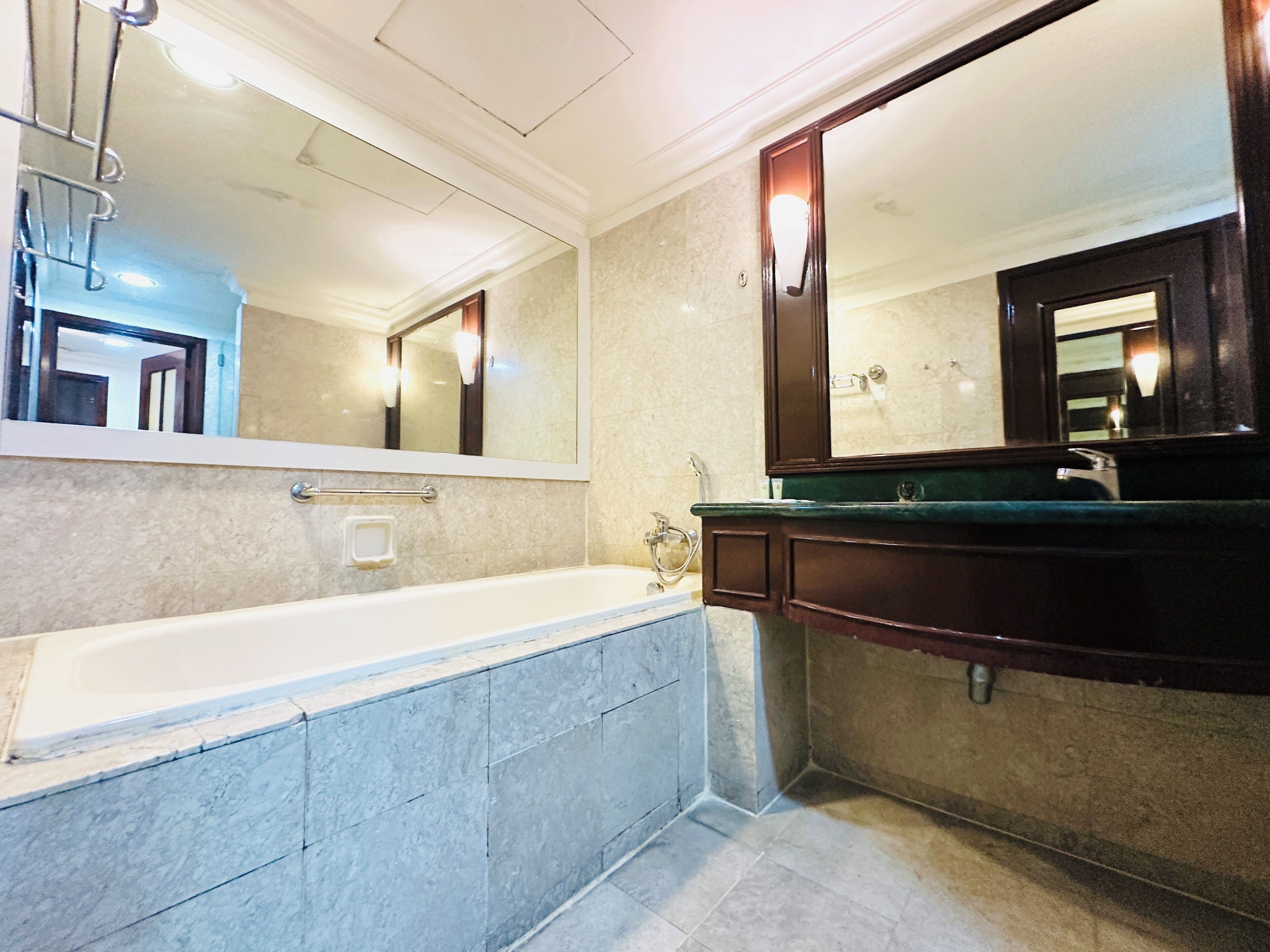 Ein Badezimmer mit einer Badewanne, einem Waschbecken mit Spiegel und einem Handtuchhalter.