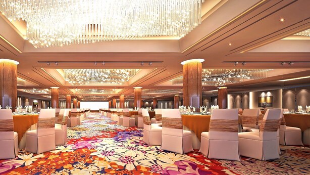 A spacious banquet hall with rows of tables and chairs, a large chandelier, and a patterned carpet. - Winnerway Hotel (Dongguan)