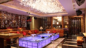 A luxurious lobby with a central seating area, a chandelier, and a wall of framed pictures. - Winnerway Hotel (Dongguan)