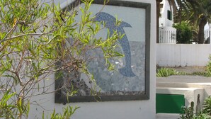 Ein Gebäude mit einem Mosaikfenster, einer weißen Wand und einer grünen Tür.