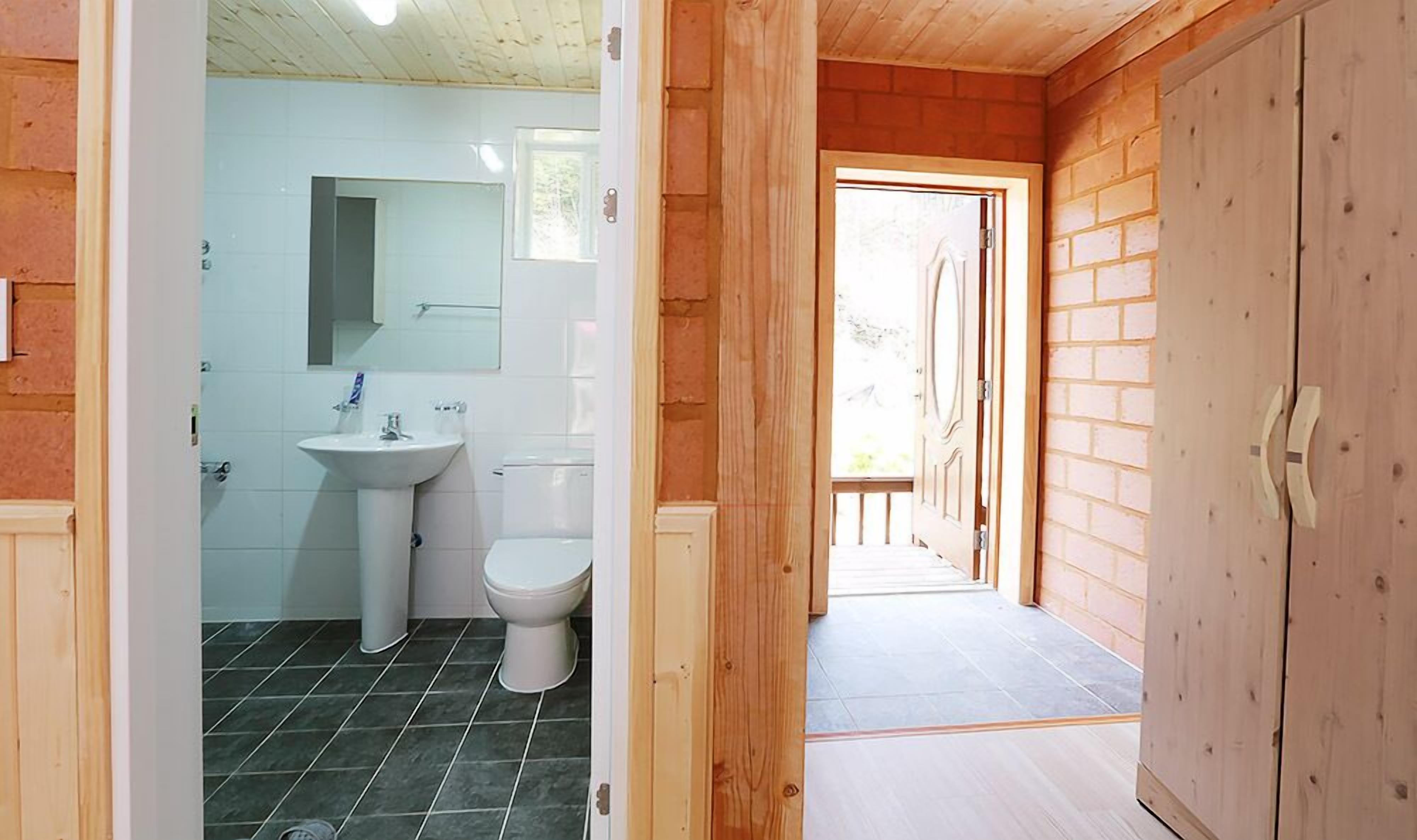 Un baño con lavamanos, inodoro y espejo.