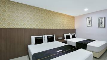 Habitación de hotel con dos camas, papel tapiz estampado y cuadros en la pared.